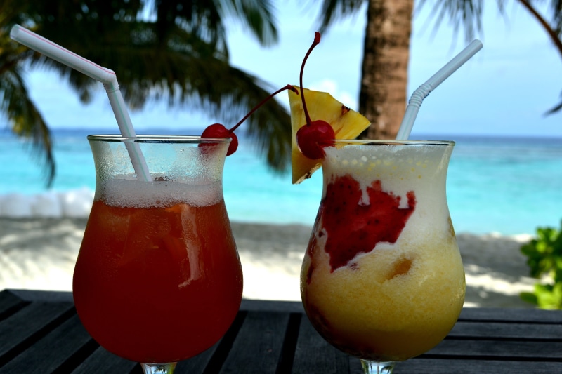 cocktail, fruit, glasses, household equipment, focus on foreground, straw, horizon over water, summer, day, palm trees, swimming pool, nature, close-up