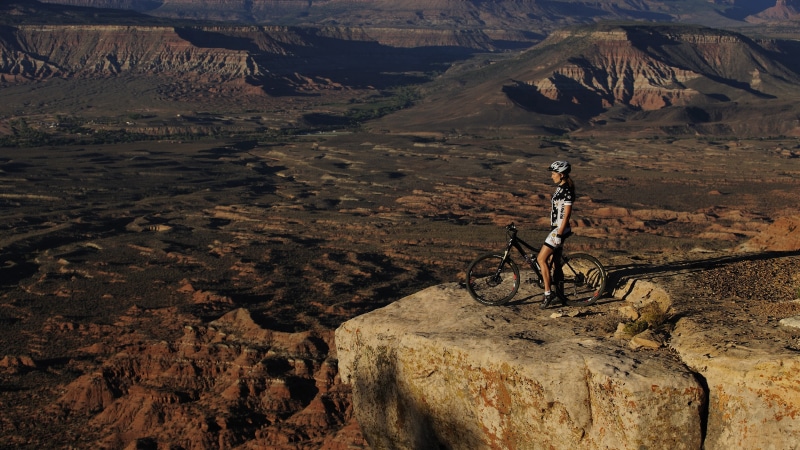 mountain bikes, arid climate, rock, climate, beauty in nature, land, one person, remote, day, lifestyles, outdoors, high angle view, formation, mountains