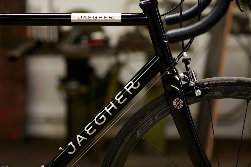 close-up, bicycle, cycling, tire, wheel, outdoors, wheels, stationary, handlebar, selective focus, spoke, metal, 1080P, sign, western script, focus on foreground