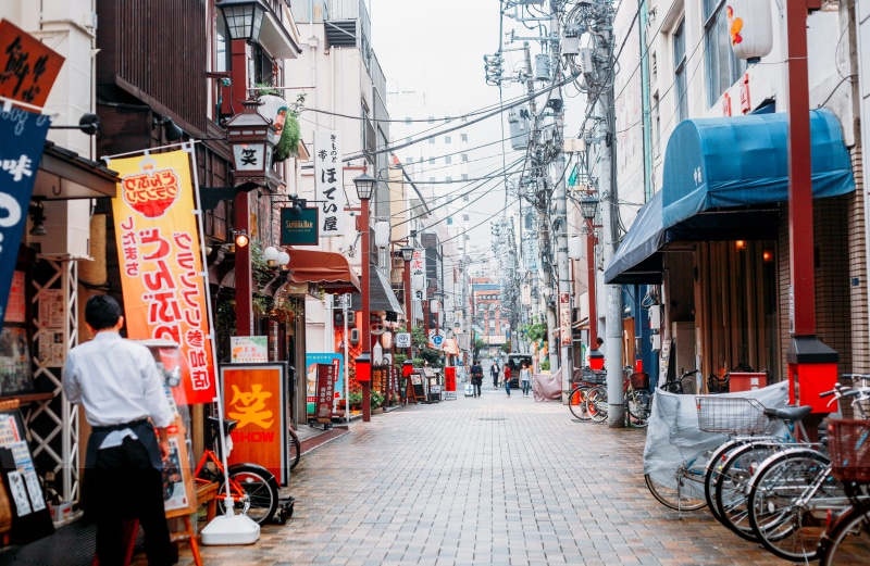 outdoors, land vehicle, real people, building, town, city street, tokyo, sign, alley, commercial sign, mode of transportation, bicycle, person, the way forward