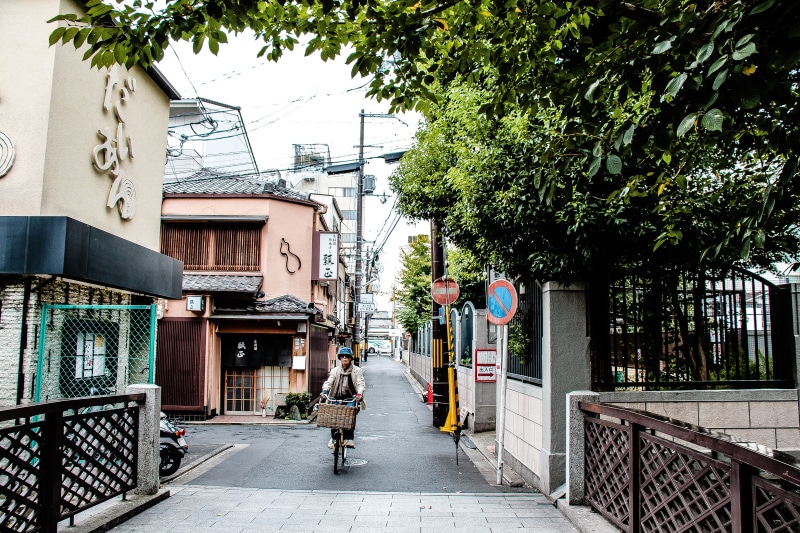 girls, tree, building exterior, japanese, plant, men, japan, city, alley, walking, day, bicycle, bicycles, footpath, built structure, travel, kyoto, bridge