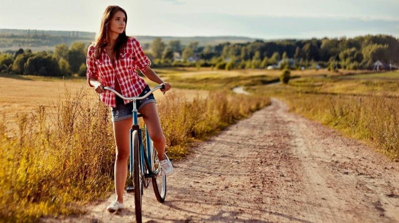 road, dirt, adult, daytime, casual clothing, front view, bike, riding, hairstyle, landscape, model, young women, outdoors, real people, nature, plant, bicycle