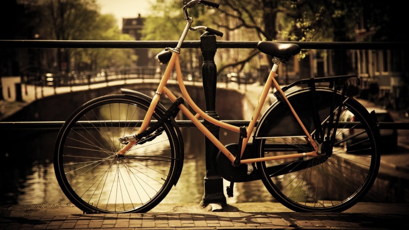 city, railing, spoke, built structure, day, security, transportation, barrier, land vehicle, focus on foreground, mode of transportation, bike, boundary