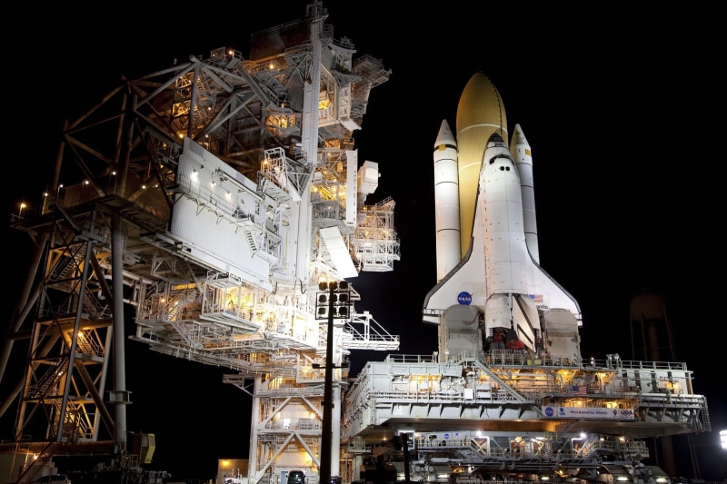 built structure, architecture, sculpture, belief, flight, outdoors, yellow, astronaut, white, building exterior, travel, rocket, travel destinations, mission