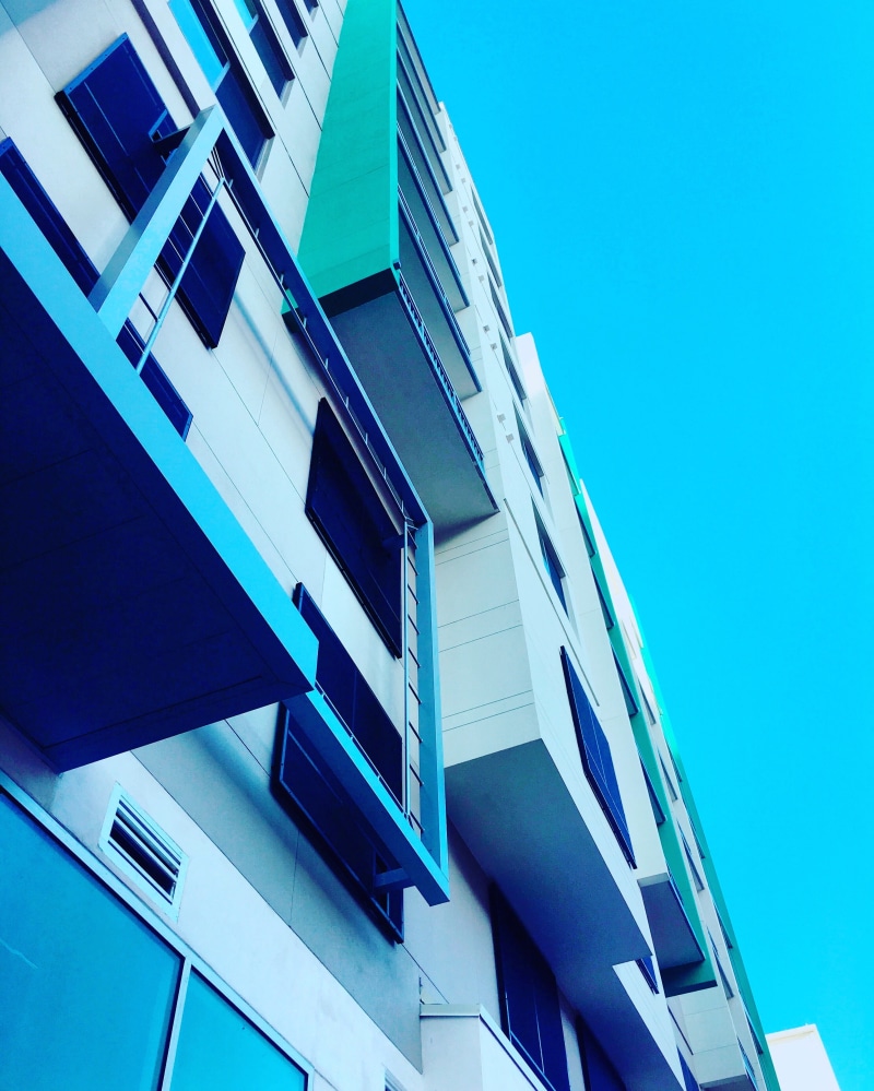 skyscraper, building exterior, clear sky, blue, architecture, apartment, low angle view, facade, building, residential district, office, window, office building exterior