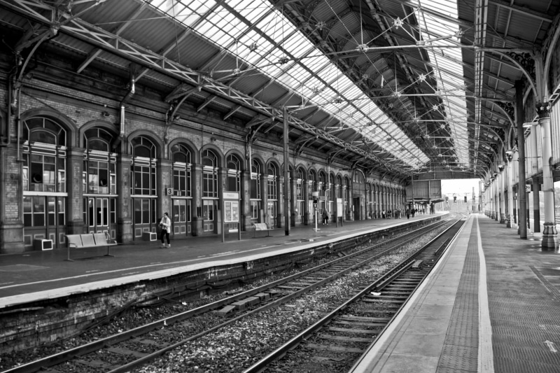 railway, indoors, railroad station, 5K, direction, day, monochrome, track, old building, railing, architecture, arch, mode of transportation, empty, grayscale