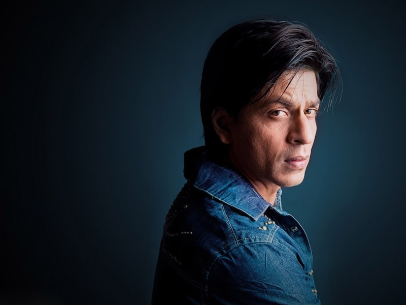 side view, casual clothing, denim, blue, photoshoot, serious, khan, one person, headshot, looking, hairstyle, portrait, indoors, black background, studio shot