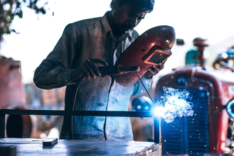 wheel, steel, mask, manufacture, smoke, focus on foreground, young adult, worker, men, welding, cutting, metal, safety, machine, sparks, holding, industry