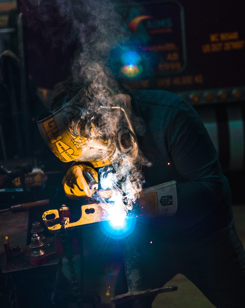 workshop, holding, real people, indoors, weld, join, technology, mask, one person, fuse, electric, stick, glow, front view, glowing, steel, helmet, yellow