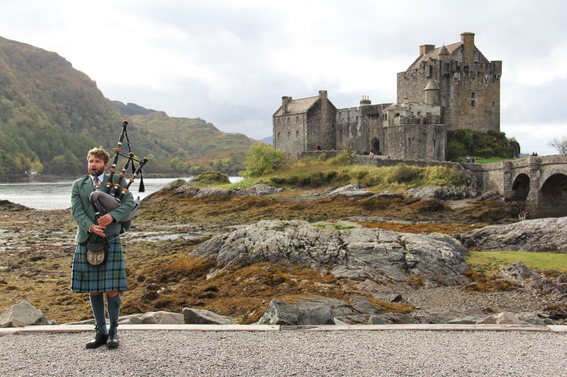 isle of skye, castle, performer, history, architecture, travel, bagpipe, standing, full length, person, kilt, cloud - sky, outdoors, sky, uniform, two people