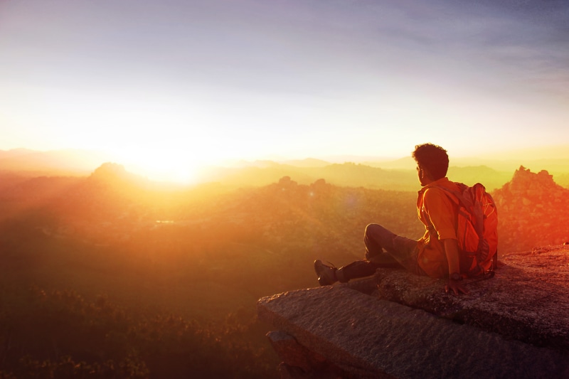 relaxation, real people, sunrays, outdoors, sky, golden hour, mountain, sunlight, travel, one person, backlit, evening, activity, rock, scenics - nature