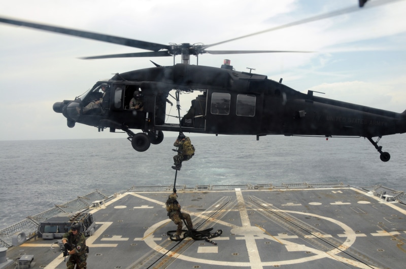 nautical vessel, compound, day, ship, vehicle, incidental people, transportation, air vehicle, navy, propeller, sky, water, soldier, unrecognizable person