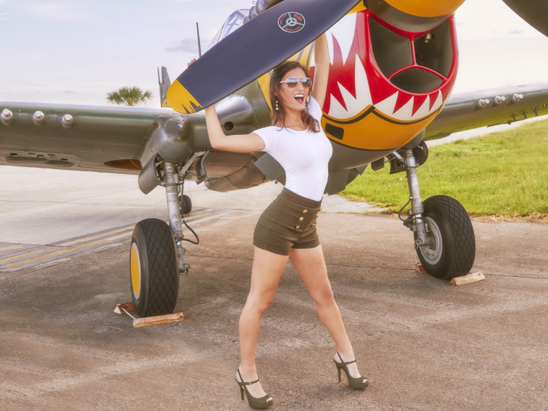 uniform, real people, airport runway, airplane, mode of transportation, fashion, young women, private airplane, one person, airport, full length, day, lifestyles