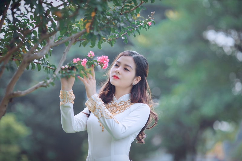 real people, focus on foreground, pink, teenager, petaled, 5K, leisure activity, beauty, holding, long hair, dress, nature, hairstyle, plant, front view