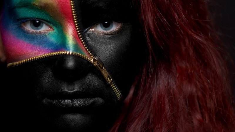 young adult, looking at camera, portrait, black background, make-up, dyed red hair, human face, headshot, women, body paint, zippers, model, one person
