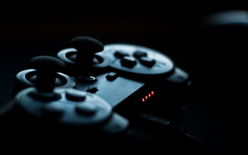 PlayStation, remote control, selective focus, controllers, single object, telephone, arts culture and entertainment, no people, blue, black background