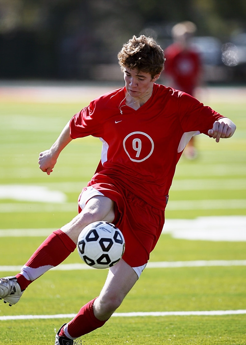 sports equipment, soccer, playing, clothing, sport, determination, player, action, sports balls, boy, soccer team, school, grass, outdoors, soccer player