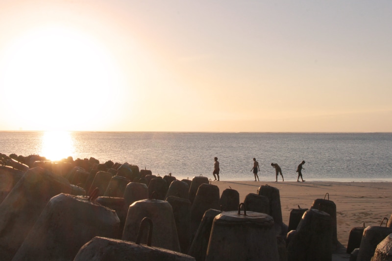 large group of people, game, shore, vacation, person, friendship, sand, siblings, together, boy, sunlight, soccer, recreation, beauty in nature, leisure activity