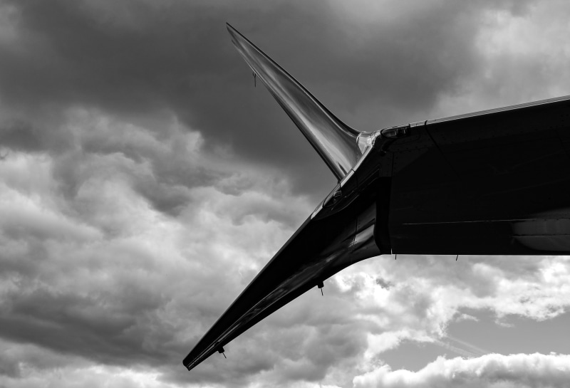 wing, aviation, winglet, building exterior, transport, outdoors, travel, ominous, architecture, built structure, overcast, airplane, day, cloudscape, cloud - sky