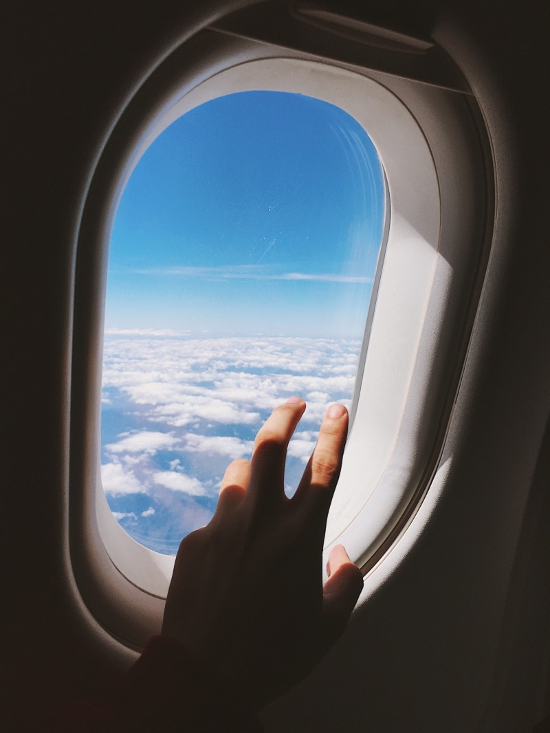 left, body part, air vehicle, light fixture, window, light, hand, transportation, bottle, curtain, flare, space station, flying, hole, car seat, near, plane