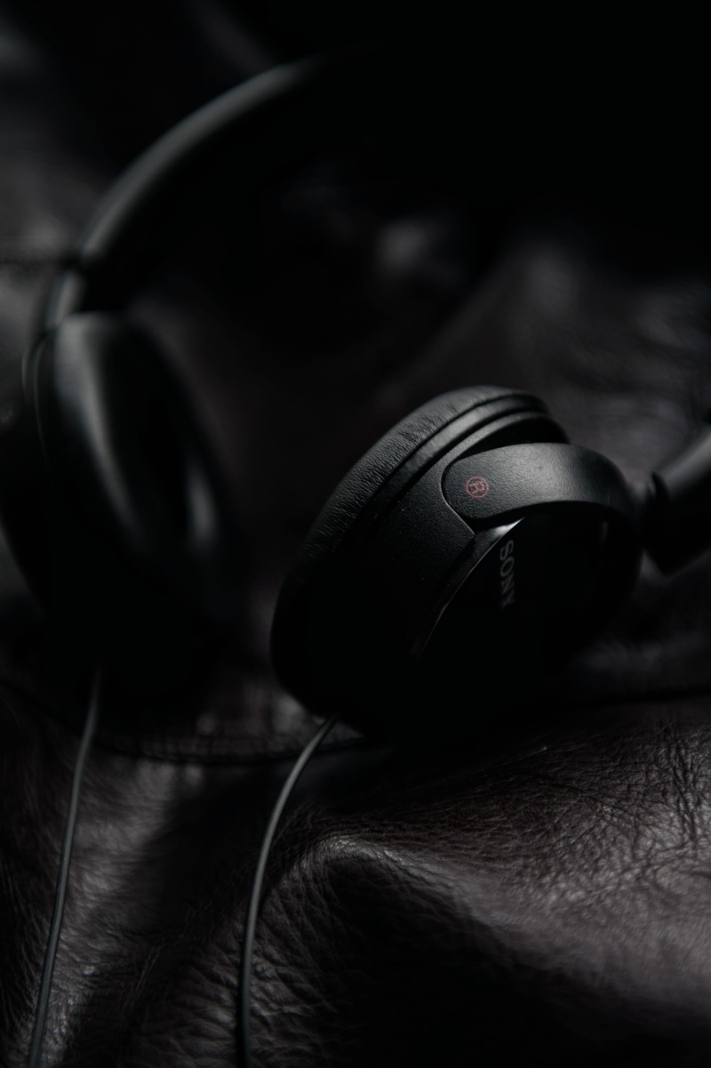 close-up, black color, one person, land vehicle, black, car, technology, sony, protection, leather, music, motor vehicle, transportation, human body part