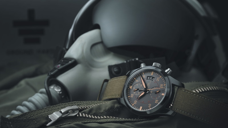 chronograph, personal accessory, black, still life, green, close-up, wristwatch, helmet, clock face, focus on foreground, black color, studio shot, strap
