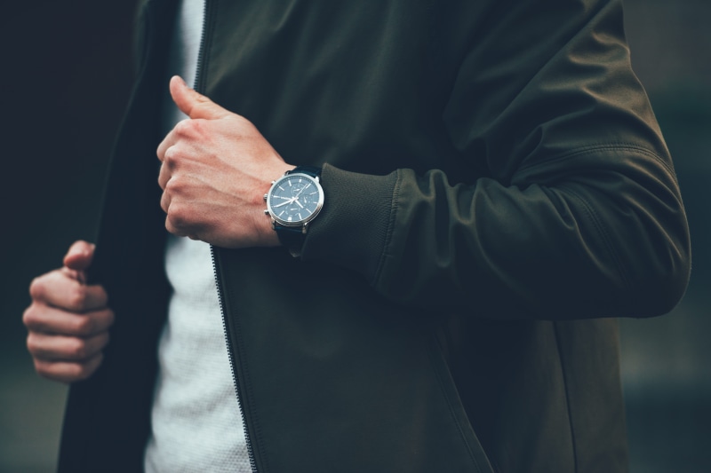 indoors, man, clock, human limb, human hand, fashion, one person, close-up, boss, front view, round, style, wristwatch, outdoor, black jacket, holding