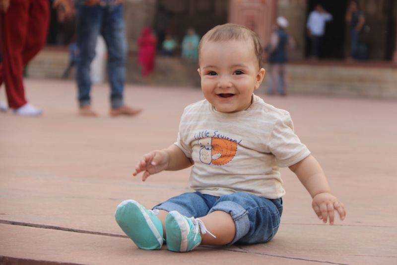 sitting, child, full length, portrait, flooring, front view, badshahi mosque, young, beautiful baby boy, casual clothing, little baby, looking at camera