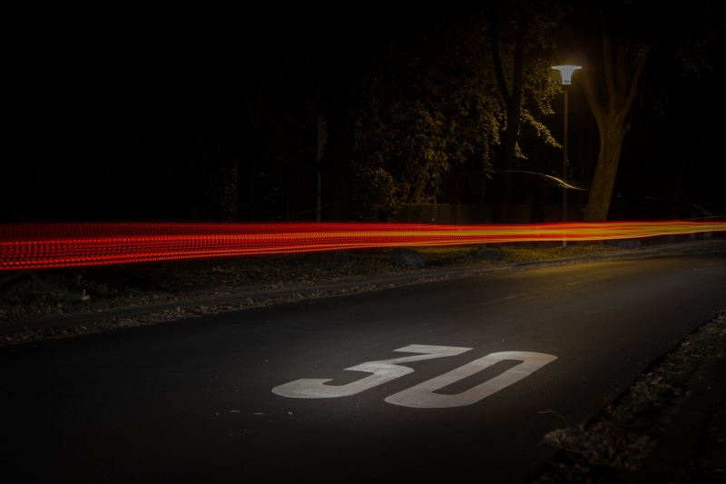 evening, park, blurred motion, road, illuminated, sign, speed, road sign, nature, light trail, lamp post, night, street, communication, turned, city, text