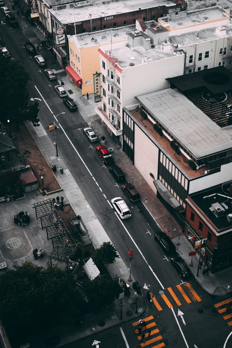 automobile, mode of transportation, transportation, symbol, tarmac, building, building exterior, street, near, crosswalk, person, nature, landscape, built structure