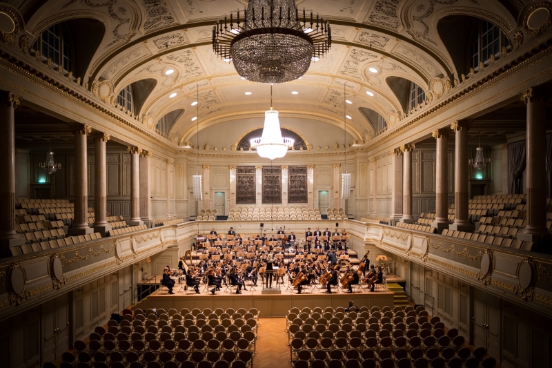 electric lamp, the past, in a row, real people, illuminated, lighting equipment, government, seats, men, arch, seat, chandelier, crowd, orchestra, audience