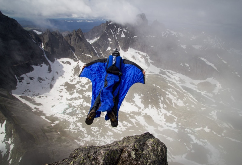 non-urban scene, tranquil scene, mountains, solid, rock - object, base jumping, pilot, snow, mountain peak, black, snowcapped mountain, parachute, clouds