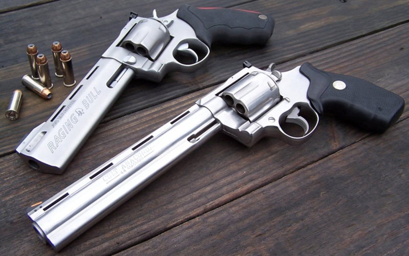 indoors, wood - material, table, ammunition, sign, revolver, steel, high angle view, communication, warning sign, still life, weapon, Taurus, stainless steel