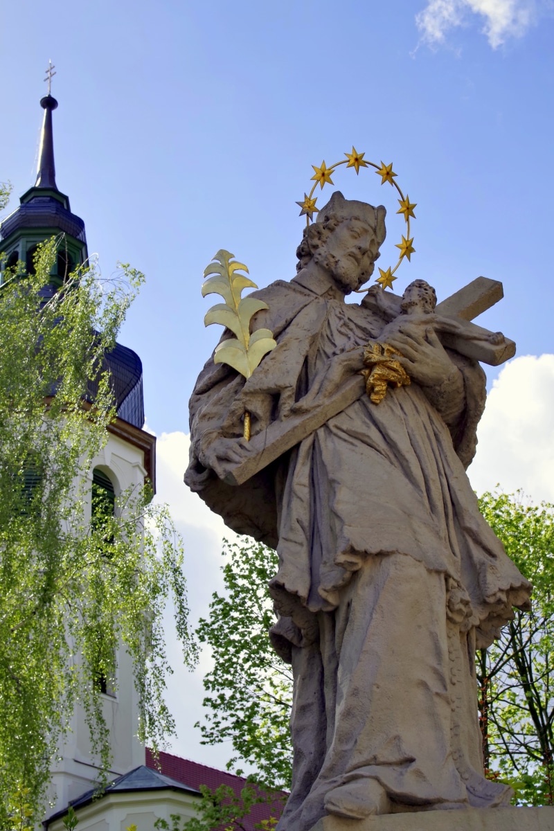 male likeness, tree, sky, art and craft, figure, religion, day, silesia, water, the patron, tall, low angle view, craft, sculpture, spirituality, human representation