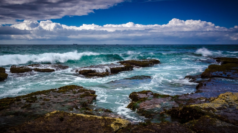 rock - object, power in nature, water, australia, landscape, land, breaking, outdoors, clouds, waves, 4K, cloud - sky, aquatic sport, sport, horizon, surfing