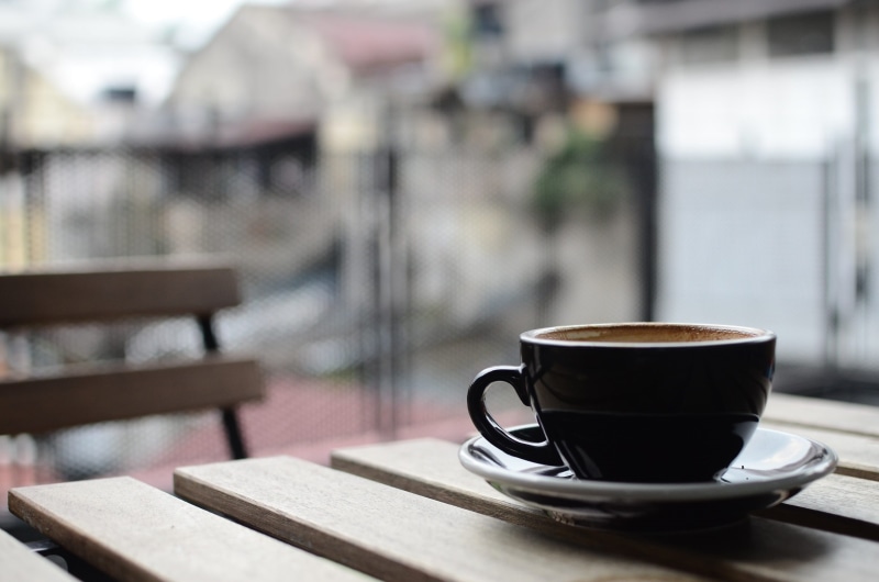 ceramic, outdoors, drink, black, focus on foreground, food and drink, wooden, brown, coffee shop, business, latte, coffee break, table, cup, coffee - drink
