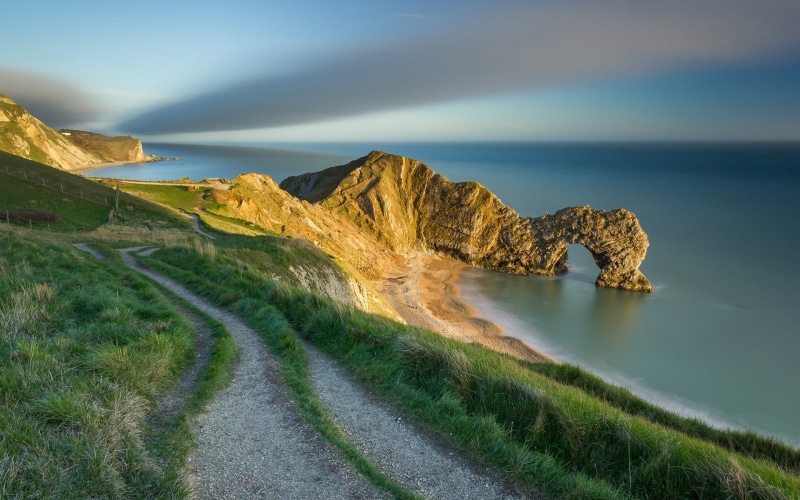 clouds, rock formation, green color, path, sand, landscape, cliff, land, tranquil scene, coast, beauty in nature, day, plant, no people, sky, water, horizon over water