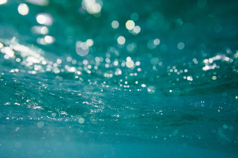 surface level, turquoise colored, reflection, backgrounds, splashing, wet, 5K, water, day, selective focus, sea, ocean, close-up, blue, defocused, nature