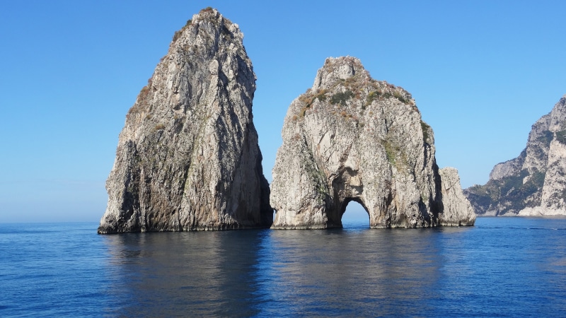 beauty in nature, arch, capri, stack rock, city, island, natural arch, tranquil scene, rock, amalfi, water, eroded, sky, blue, clear sky, idyllic, rock - object
