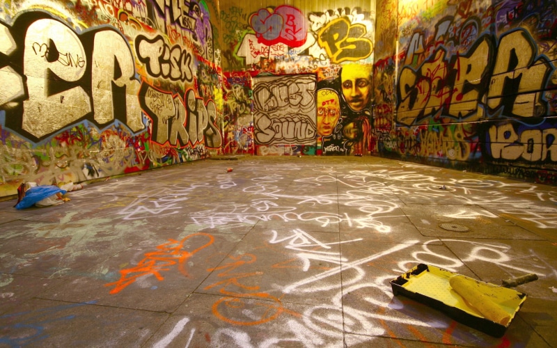 western script, 2K, day, wall - building feature, wooden, graffiti, male likeness, craft, mattress, mural, multi colored, built structure, flooring, representation
