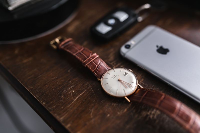 high angle view, minute hand, wood - material, male, indoors, accuracy, leather, grey iphone, watch, single Object, still life, iphone, old-fashioned, essentials
