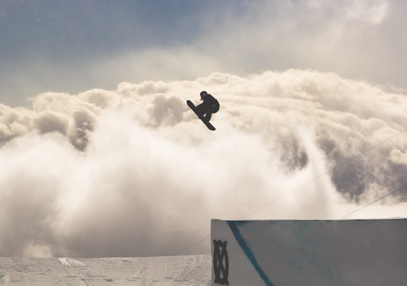 leisure activity, winter, mid-air, low angle view, adventure, switzerland, snowboarding, cloud - sky, 2K, stunt, slopestyle, flying, nature, jumping, one person