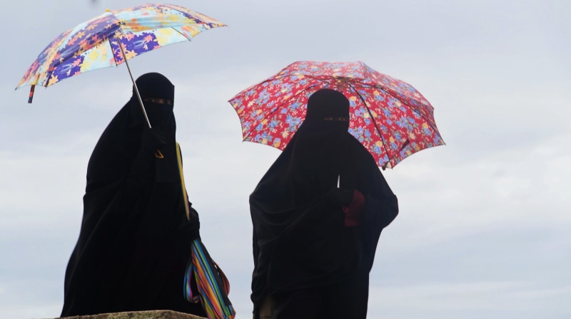 two people, adult, niqab, real people, outdoors, security, people, three quarter length, muslims, cloud - sky, sky, multi colored, protection, day, person