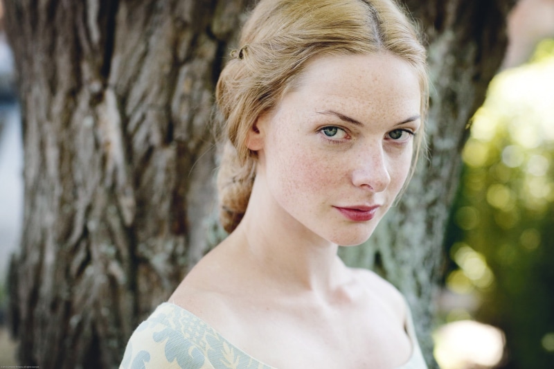 focus on foreground, freckles, tree trunk, hair, women, neck, 1080P, contemplation, tree, top, trunk, looking at camera, day, blonde, beautiful woman