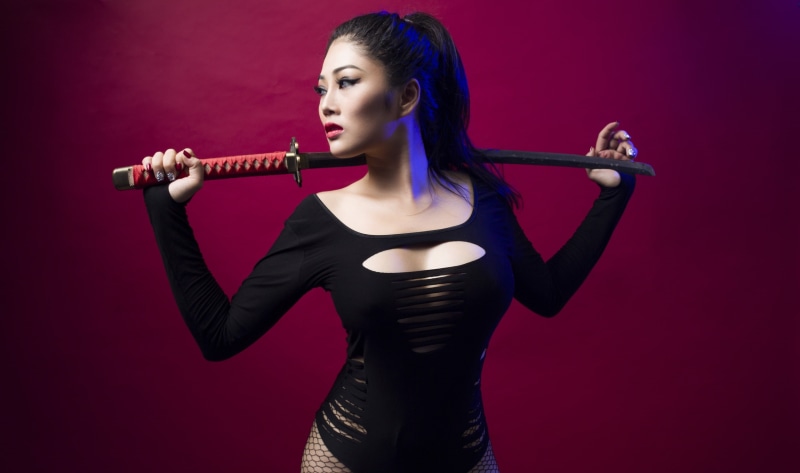 sword, indoors, colored background, young adult, Asian, elegance, fashion, glamour, red background, one person, musician, clothing, performance, katana