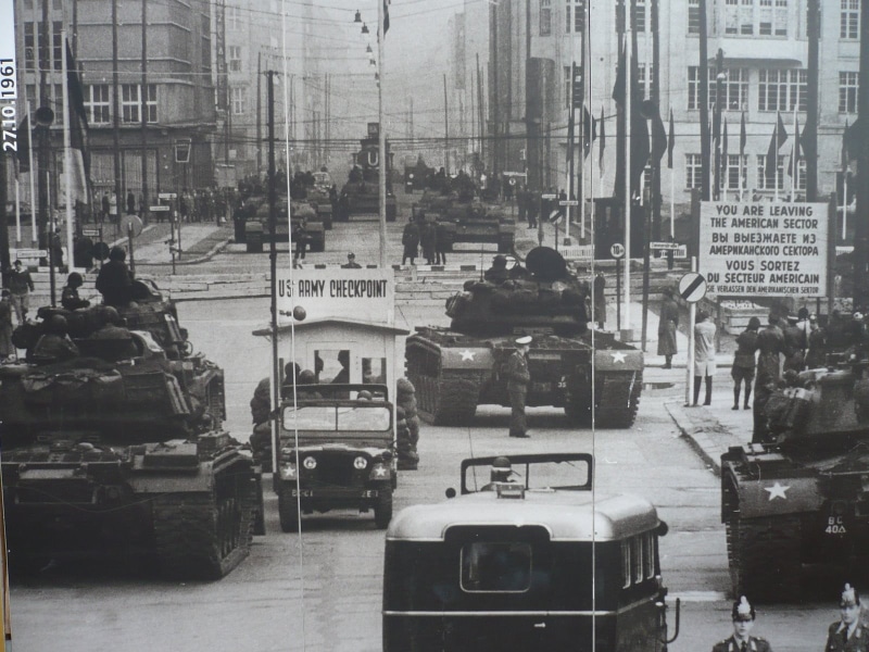 incidental people, bus, building, building exterior, soldier, men, public transportation, city, mode of transportation, vintage, street, berlin wall, day