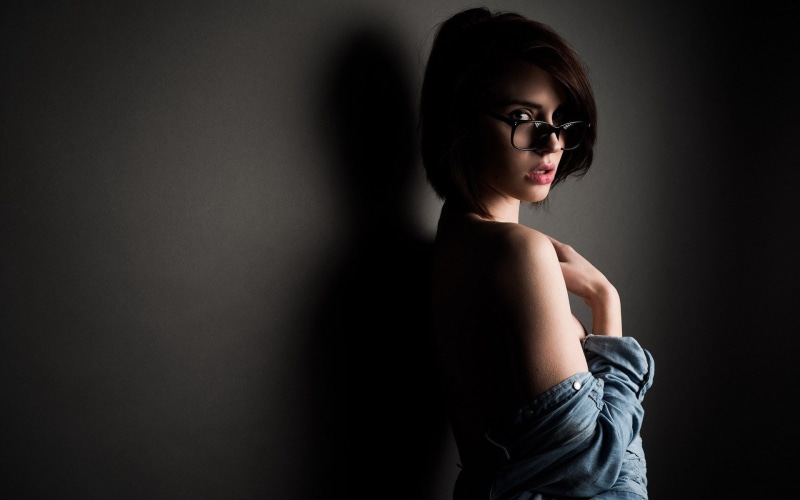 1080P, copy space, hairstyle, one person, black background, contemplation, portrait, women, waist up, looking at camera, dark, looking, beautiful woman