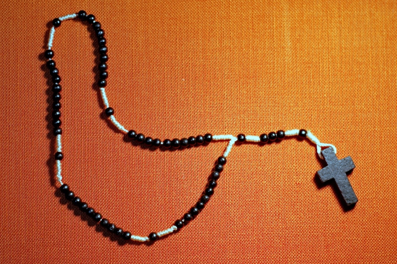 chain, catholicism, indoors, catholic, bracelet, christianity, sacrament, devotion, bead, studio shot, religious, rosary, jesus, orange color, black, emotion