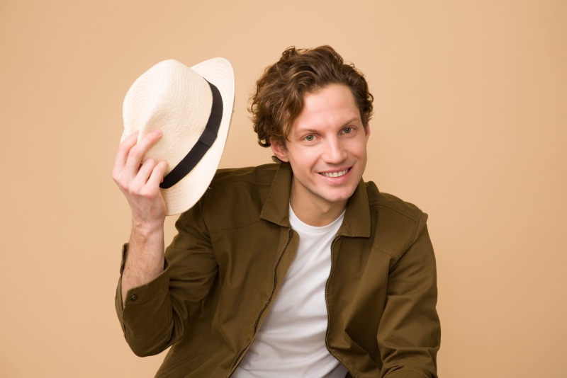fun, happiness, holding, facial expression, young men, fashion, person, men, studio, smiling, looking at camera, colored background, wear, one person, looking
