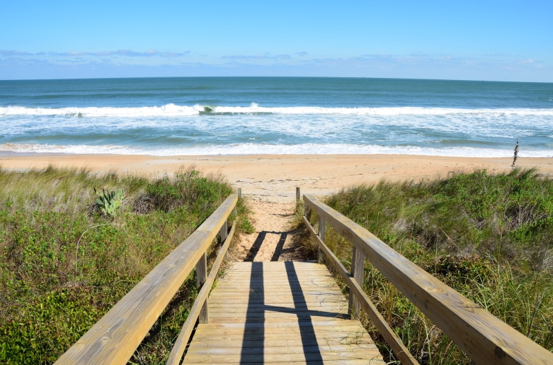 no people, beach, blue, walkway, grass, seaside, horizon over water, nature, near, coast, vacation, sky, footpath, seashore, water, seascape, sunny, railing